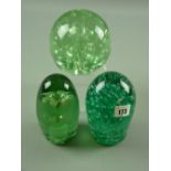 Three 19th Century green glass dump weights, one with internal floral inclusion, the remaining two