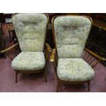 A pair of Ercol stick back armchairs with button upholstered backs and seats