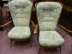 A pair of Ercol stick back armchairs with button upholstered backs and seats