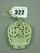A green jade pendant in the form of a vase of flowers, 6 x 5 cms