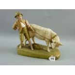 A Royal Dux figurine of a bull with its young handler on an oblong base, no. 1494, 27 cms long, 27