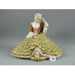A fine later Royal Dux figurine of a young lady in flowing dress seated on a couch reading a book