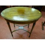 An oval top inlaid mahogany side table with crossbanded frieze on tapering supports with 'X' frame