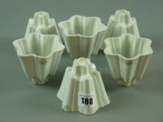 A set of six Shelley pottery jelly moulds, all matching, 7 cms high (edge nibbles)