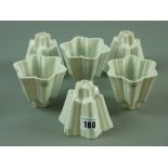 A set of six Shelley pottery jelly moulds, all matching, 7 cms high (edge nibbles)