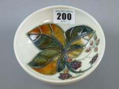 A Moorcroft Blackberry footed shallow bowl on a grey/blue ground, underglazed blue impressed and