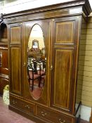 An Edwardian mahogany and line inlaid triple wardrobe, a stepped cornice over two twin panelled
