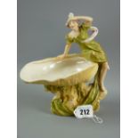 A Royal Dux figurine of a young lady seated on a shell dish, model no. 818 to the base, 19 cms high