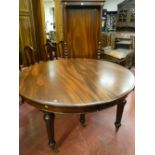 An excellent quality oval mahogany pull-out dining table on six turned and reeded supports with