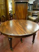 An excellent quality oval mahogany pull-out dining table on six turned and reeded supports with