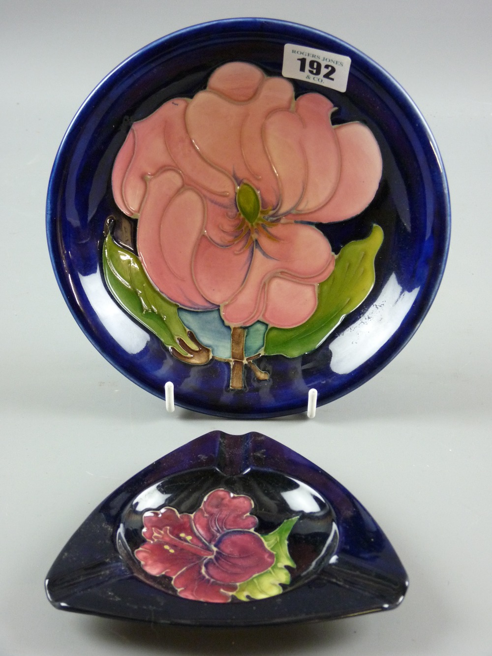 A Moorcroft Magnolia blue ground dish, 18.5 cms diameter, impressed marks and painted signature to