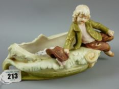 A Royal Dux figurine of a young boy seated on an oval dish, 13 cms high