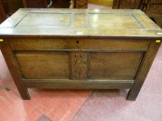 An 18th Century oak coffer having a twin inset panel peg jointed top with iron nail hinges and