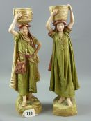 A pair of Royal Dux Eastern figurines of a standing man and standing woman each holding a basket