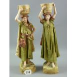 A pair of Royal Dux Eastern figurines of a standing man and standing woman each holding a basket