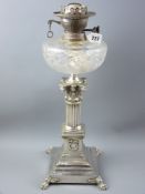 A Victorian silver plated Corinthian column oil lamp with wreath and swag decorated panels above a