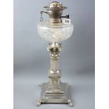 A Victorian silver plated Corinthian column oil lamp with wreath and swag decorated panels above a