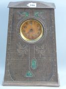 An Art Nouveau biscuit/sweet clock tin with embossed rivet edging, stylized floral pattern with