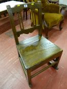 A late 18th Century farmhouse oak rocking chair of plain format with pierced and shaped back