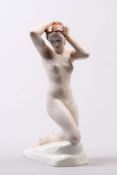 Skulptur. 20. Jh. Glasiertes Steinzeug, naturalistisch bemalt. Kniender, weiblicher Akt auf ovalem