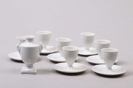 Konvolut. Sieben Eierbecher, kleine Vase. Weiß glasiert. Marken Nymphenburg. H: bis 10 cm. Start