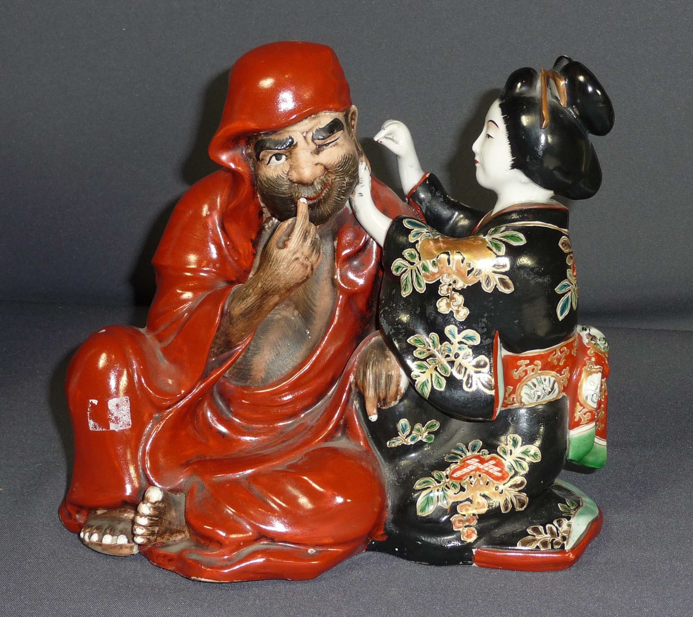 Daruma mit Geisha Japan, wohl Meiji-Periode Sitzende, stark behaarte Figur des Bodhidharma in
