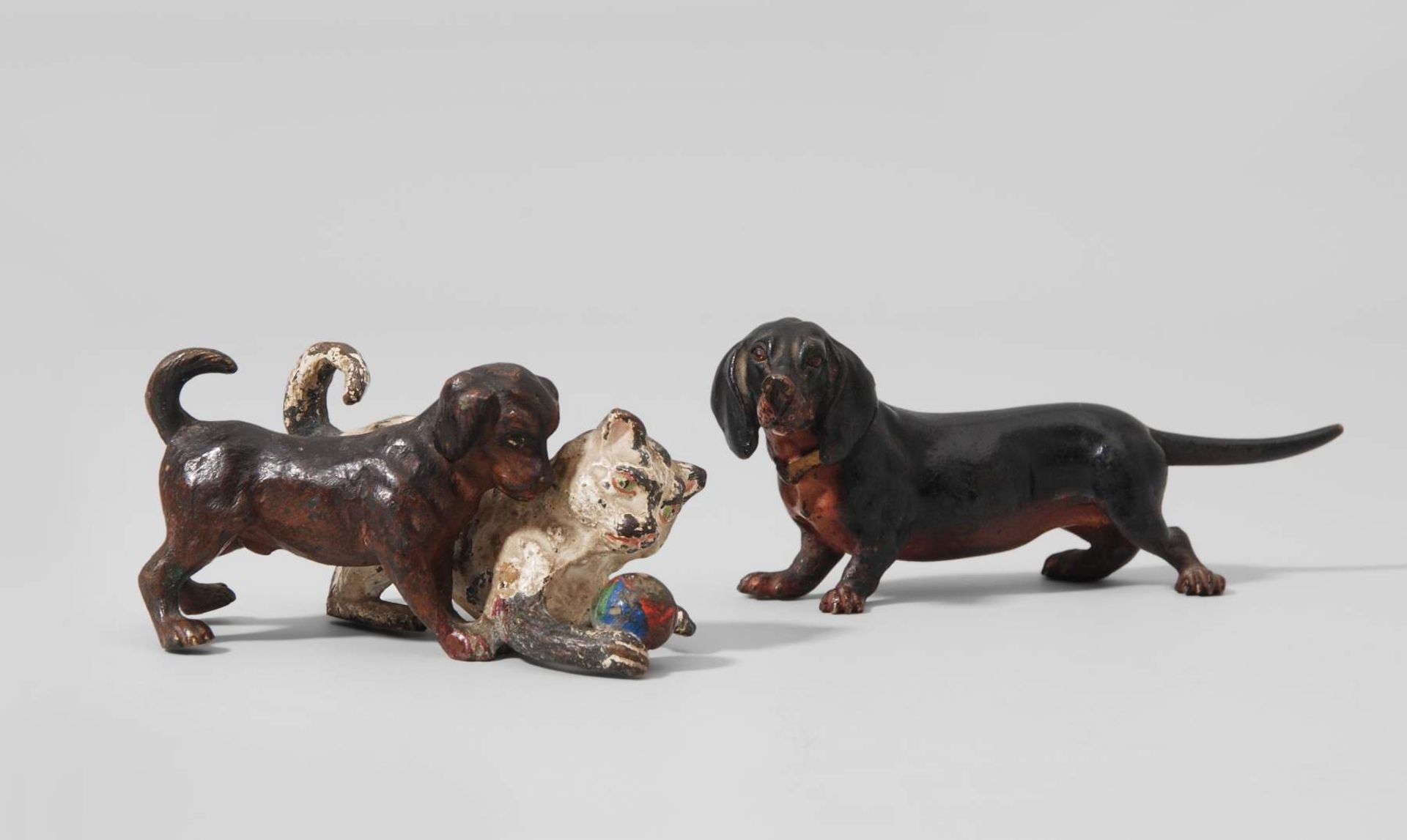 Tiergruppe: 2 Hunde, 1 Katze
Wiener Bronze, um 1900. Ziseliert und polychrom bemalt. Dackel, bzw.