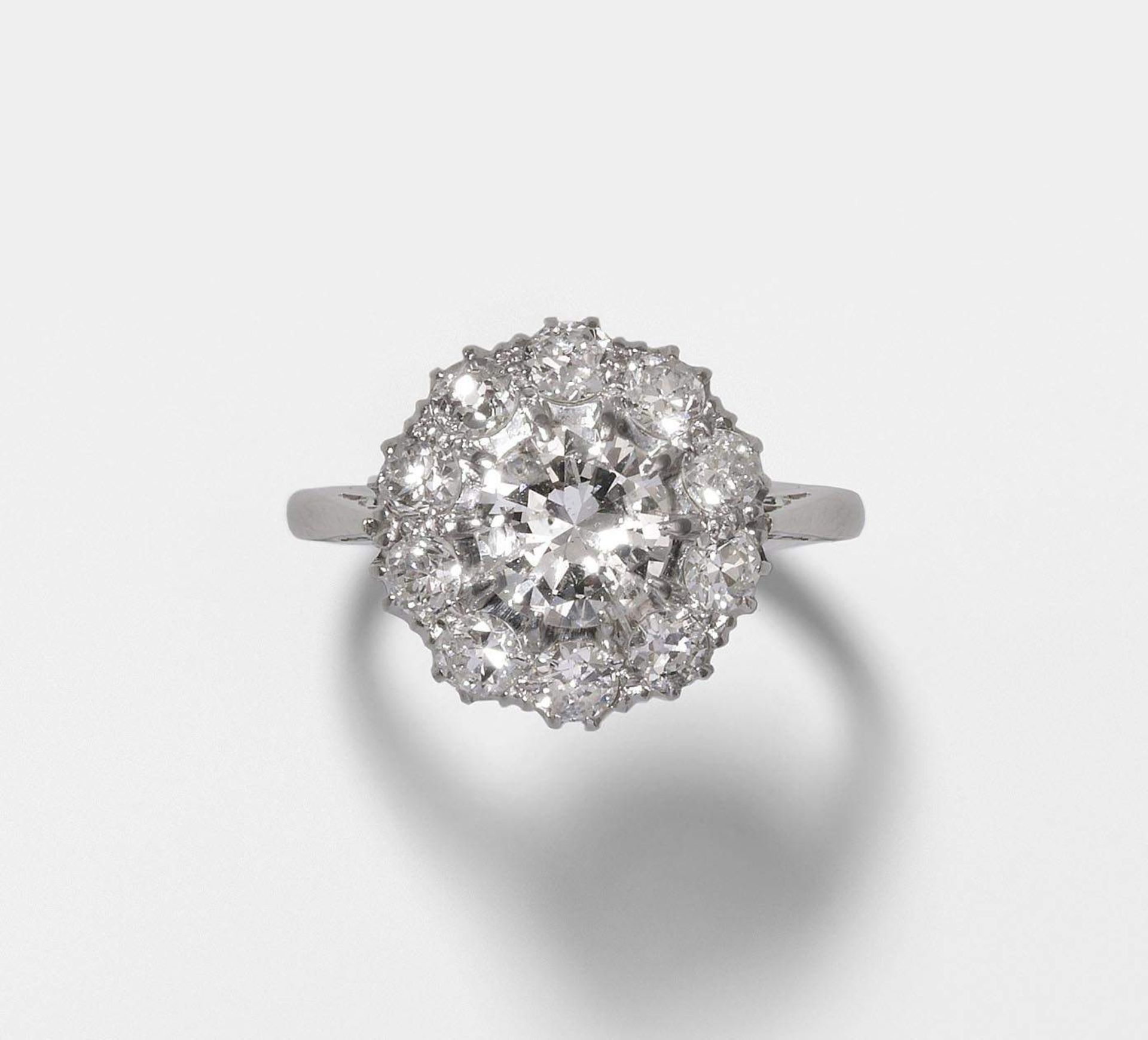 Diamant-Ring
um 1920. 950 Platin/375 Weissgold (550). Entourage-Modell mit 1 Brillant von ca. 1