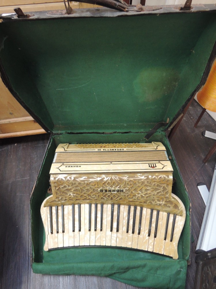 A vintage Hohner piano accordion of cream celluloid fretwork design in original case