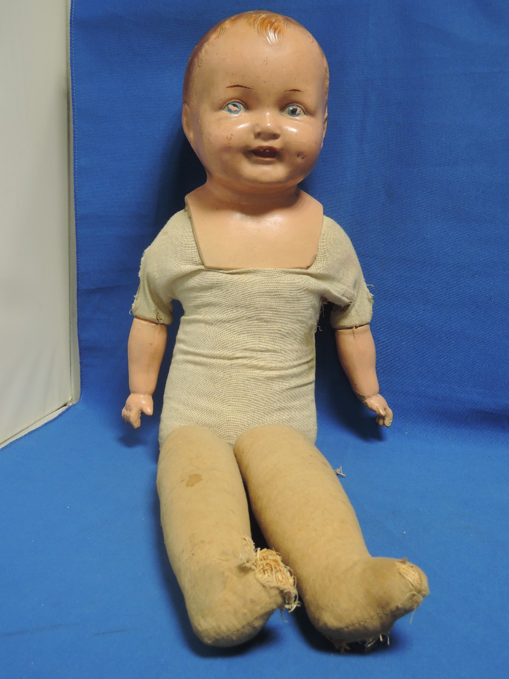 An early 20th century Reliable composition headed doll having fixed eyes and mouth, straw and