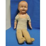 An early 20th century Reliable composition headed doll having fixed eyes and mouth, straw and