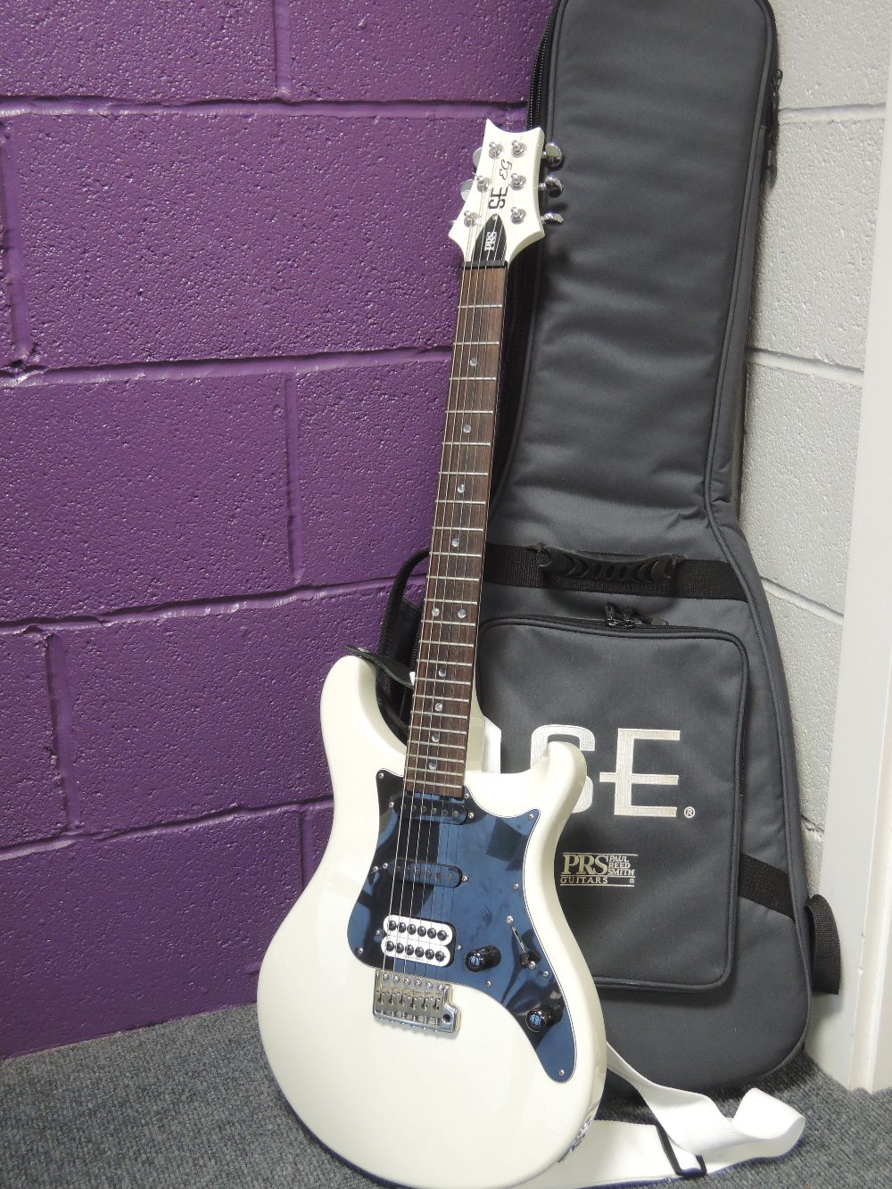 A electric guitar, by PRS, SE-EG having padded gig bag