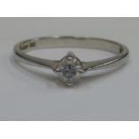 A ladies diamond solitaire ring having a raised claw setting on a platinum loop