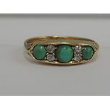 A ladies dress ring having three turquoises interspersed by diamonds in a gallery mount with moulded