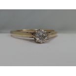 A ladies diamond solitaire ring, approx .25ct in a raised claw setting with shaped shoulders on a