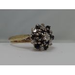 A ladies dress ring having a triple diamond and sapphire cluster on an 18ct gold loop