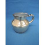 An Arts & Crafts style silver lidded jug of squat form, Birmingham 1911, Levi & Salaman