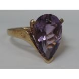 A ladies dress ring having a teardrop amethyst in a stylised mount on a 9ct gold loop