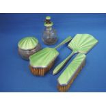 A silver dressing table set including cut glass atomiser, hand mirror, brushes and trinket pot,