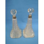 A pair of moulded glass scent bottles of tall tapered form having cut glass stoppers and HM silver