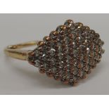 A ladies dress ring having a large diamond chip lozenge shaped cluster on a 9ct gold loop, marks