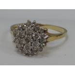 A ladies dress ring having a diamond triple cluster in a raised claw setting on an 18ct gold loop