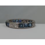 A ladies full eternity ring having diamonds and baguette cut sapphires in a white metal loop, no