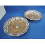 A pair of Sheffield plate decanter coasters having frilled rims with moulded grape vine decoration