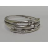 A ladies dress ring of stylised form having diamond chip decoration on a 9ct white gold loop