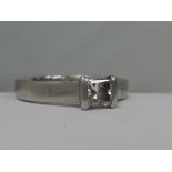 A ladies princess cut diamond solitaire, approx .5ct in a stylised mount on a platinum loop