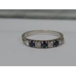 A ladies eternity ring having seven diamond and sapphires in a claw setting on an 18ct white gold