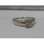 A ladies dress ring having a square diamond cluster in a raised square mount on a heavy 18ct white