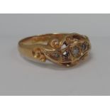 A ladies dress ring having five graduated diamonds in a moulded scroll mount on an 18ct gold loop.