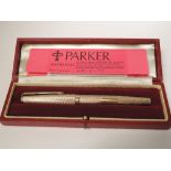 A cased 9ct gold Parker 61 Presidential fountain pen having engine turned chevron decoration.